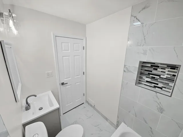 a bathroom with a toilet sink and shower