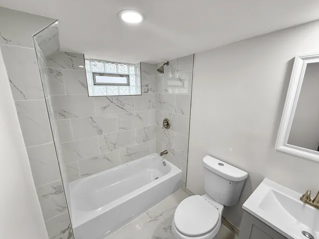 a white toilet sitting next to a bath tub