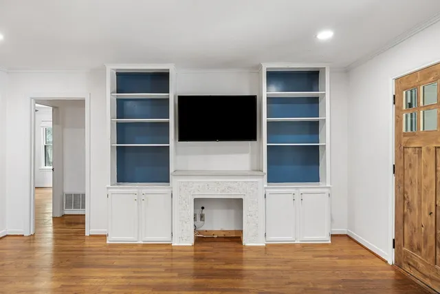 a view of an empty room with a fireplace and a window
