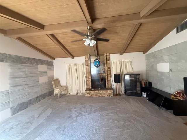 a view of a livingroom with chairs and a ceiling fan