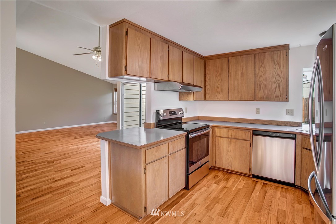 11206 Southeast 268th Street Kent, WA 98030 - Photo 11 of 23 a kitchen with a sink cabinets stainless steel appliances and a counter top space