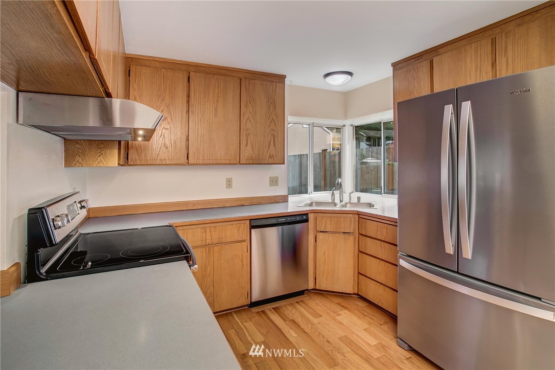 11206 Southeast 268th Street Kent, WA 98030 - Photo 12 of 23 a kitchen with granite countertop a refrigerator stove and sink