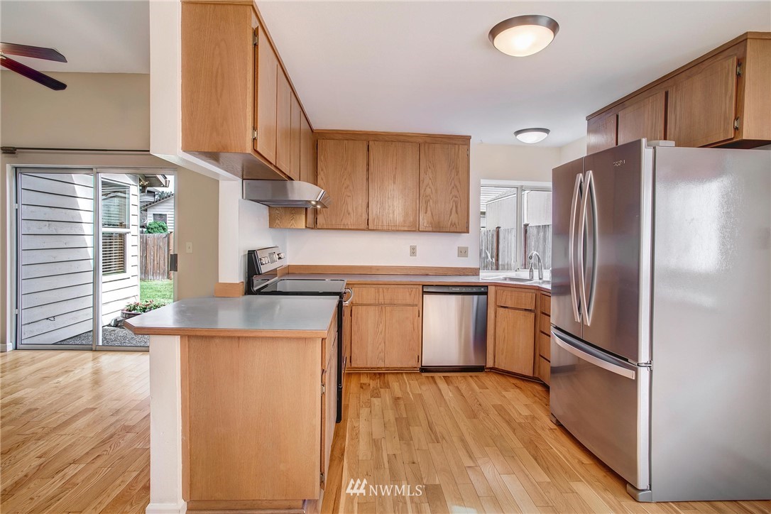 11206 Southeast 268th Street Kent, WA 98030 - Photo 14 of 23 a kitchen with a refrigerator sink and cabinets
