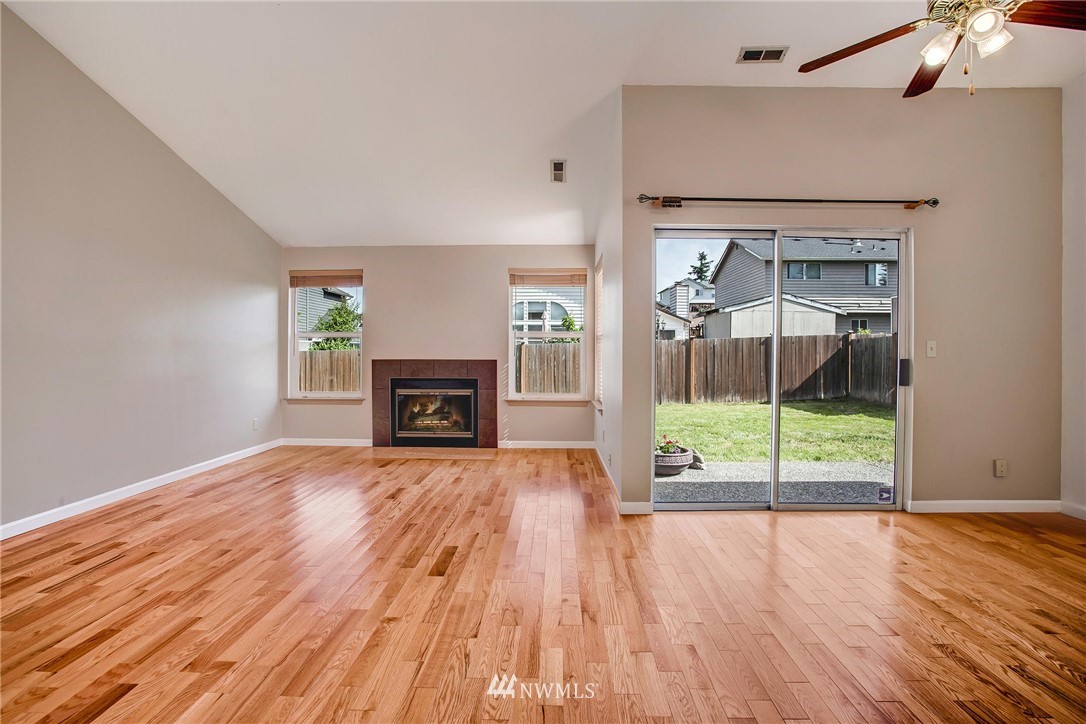 11206 Southeast 268th Street Kent, WA 98030 - Photo 7 of 23 a view of empty room with wooden floor and fireplace