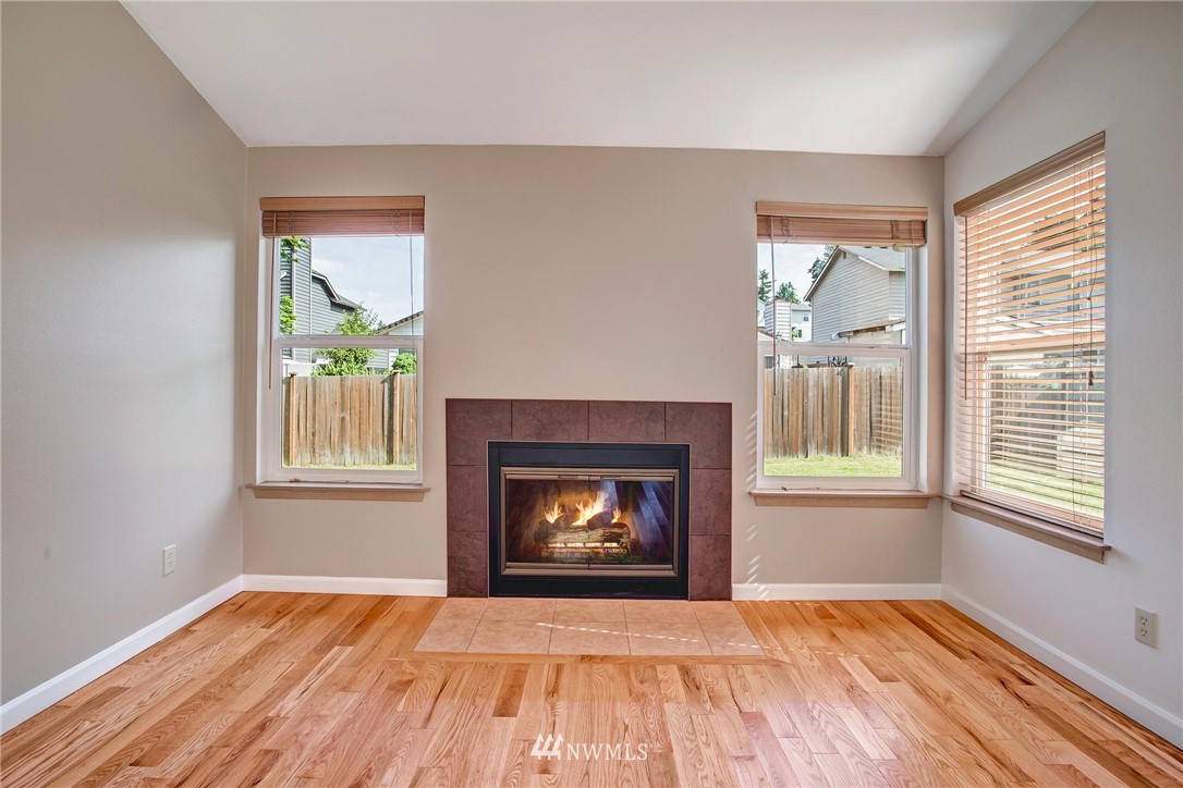 11206 Southeast 268th Street Kent, WA 98030 - Photo 8 of 23 an empty room with windows and fireplace