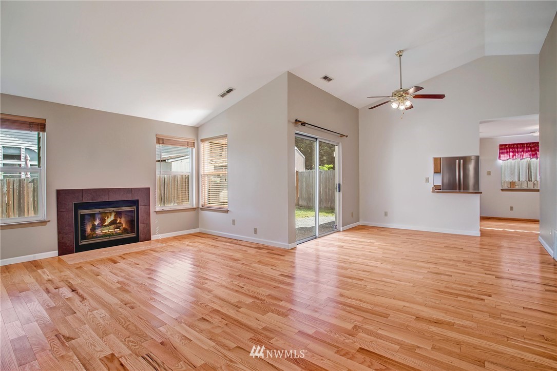 11206 Southeast 268th Street Kent, WA 98030 - Photo 9 of 23 a view of empty room with wooden floor and fireplace