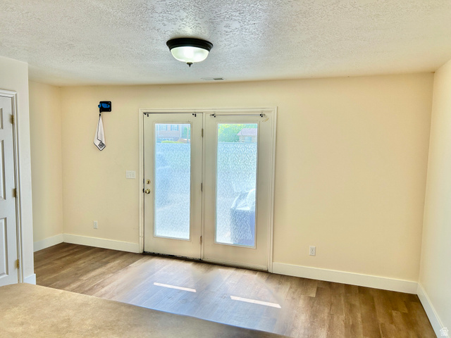 334 West Rodeo Lane South Logan, UT 84321 - Photo 3 of 12 French patio doors with frosted glass, wood-finish flooring, white baseboards, and a semi-flush ceiling light fixture