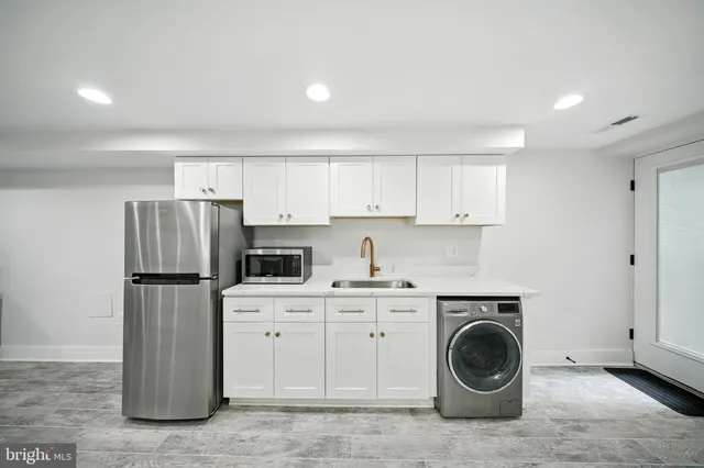 a kitchen with a sink a refrigerator and cabinets
