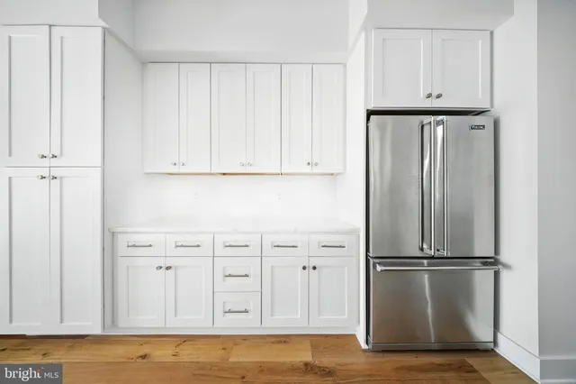 a view of kitchen with refrigerator cabinet and wooden cabinet