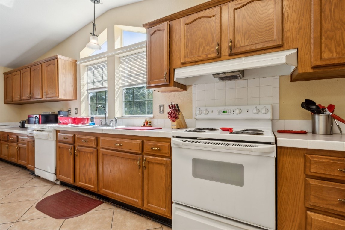 85135 Miner Road Yulee, FL 32097 - Photo 16 of 32 a kitchen with granite countertop a sink stainless steel appliances and cabinets