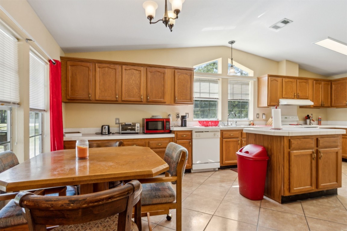 85135 Miner Road Yulee, FL 32097 - Photo 17 of 32 a kitchen with stainless steel appliances granite countertop a sink dishwasher and cabinets with wooden floor