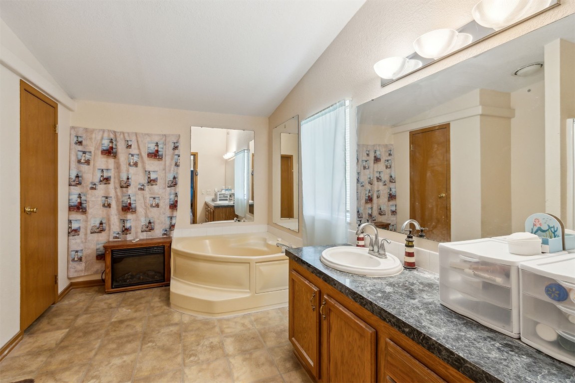 85135 Miner Road Yulee, FL 32097 - Photo 23 of 32 a bathroom with a granite countertop sink and a bathtub