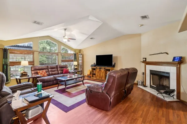 a living room with furniture a fireplace and a flat screen tv
