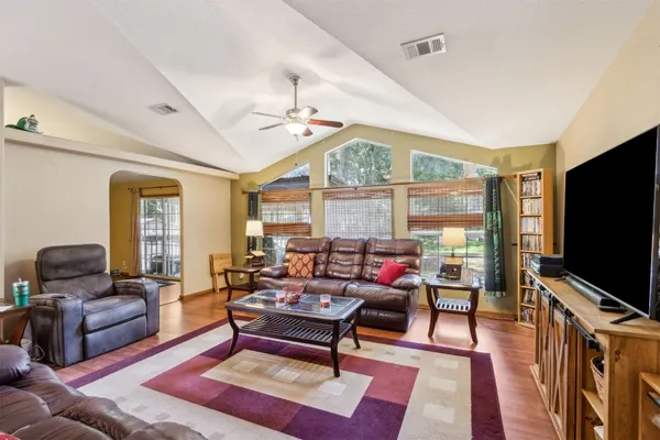 a living room with furniture a flat screen tv and a large window