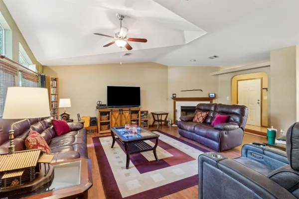 a living room with furniture a flat screen tv and a fireplace