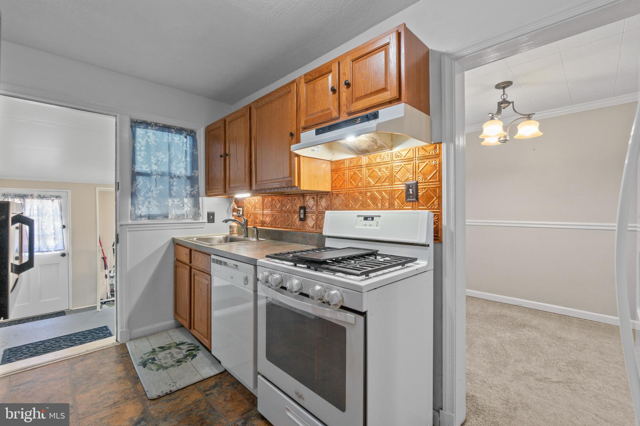 5514 Council Street Halethorpe, MD 21227 - Photo 5 of 36 a kitchen with stainless steel appliances granite countertop a stove a sink and a refrigerator