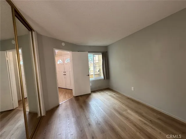 an empty room with windows closet and wooden floor