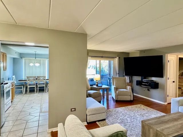 a kitchen with stainless steel appliances granite countertop a refrigerator a sink dishwasher a stove with white cabinets and wooden floor