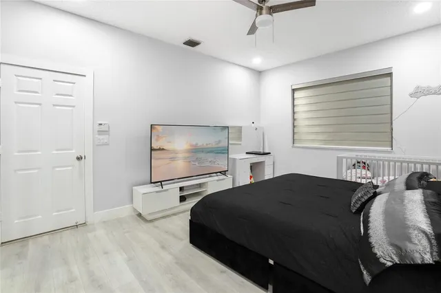 a bedroom with a bed and large windows