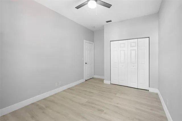 an empty room with a chandelier fan
