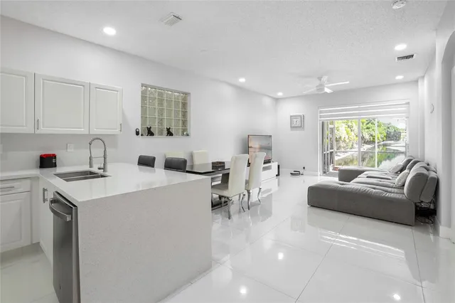 a living room with furniture a window and a view of kitchen
