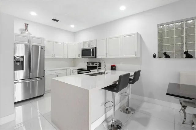 a kitchen with stainless steel appliances a refrigerator stove microwave and sink
