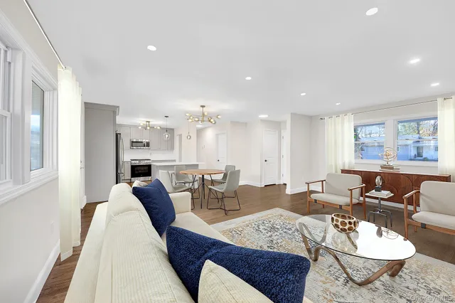 a living room with furniture and a dining table with kitchen view