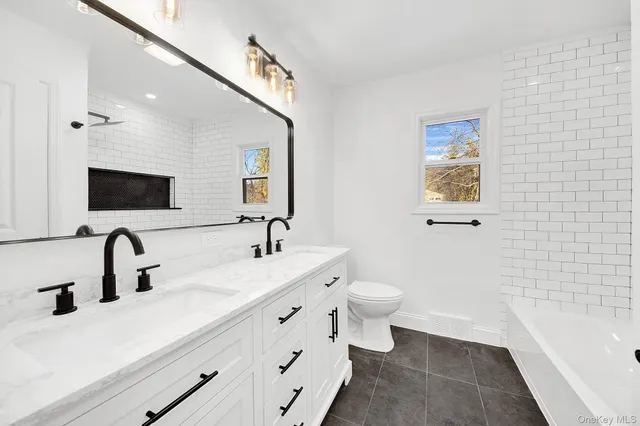 a bathroom with a double vanity sink a toilet and a mirror