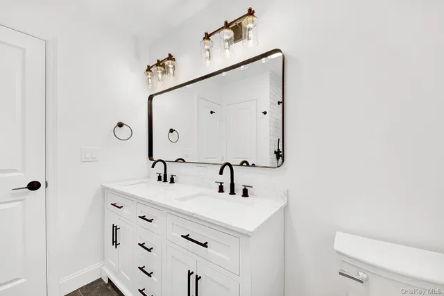 a bathroom with a sink a toilet and mirror