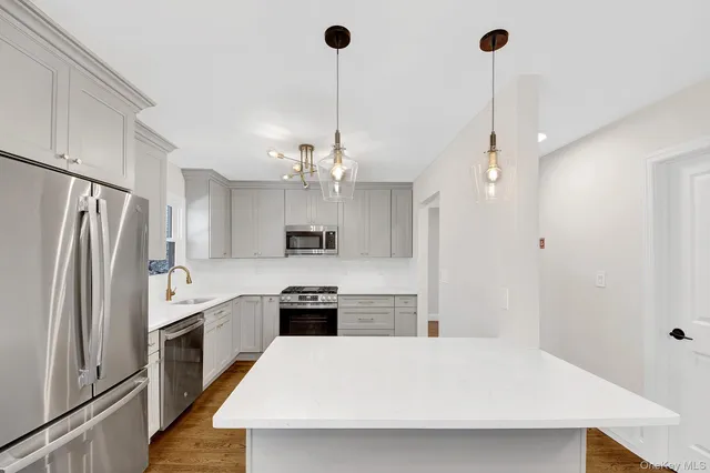 a large kitchen with stainless steel appliances a refrigerator sink and stove