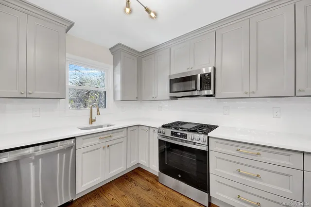 a kitchen with white cabinets stainless steel appliances and sink