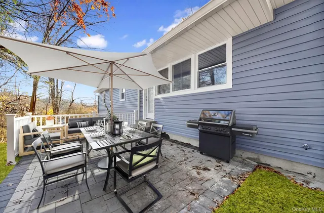 a view of a patio with a dining table and chairs with wooden floor and fence