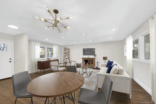a living room with furniture two window and a flat screen tv
