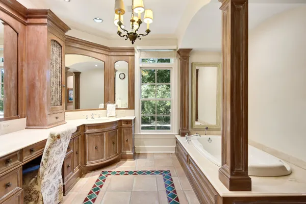 a spacious bathroom with a granite countertop tub sink and mirror