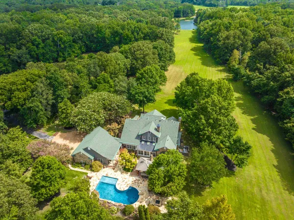 an aerial view of a house with swimming pool and garden