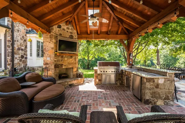 a view of a patio with couches chairs and a fireplace