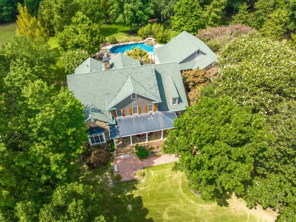 an aerial view of a house with swimming pool and garden