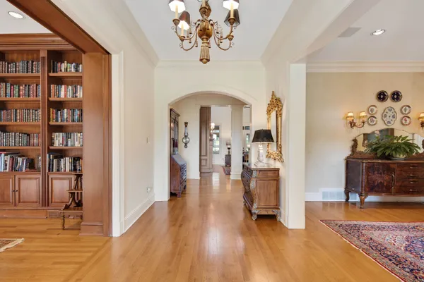 a view of a hallway with wooden floor and a potted plant