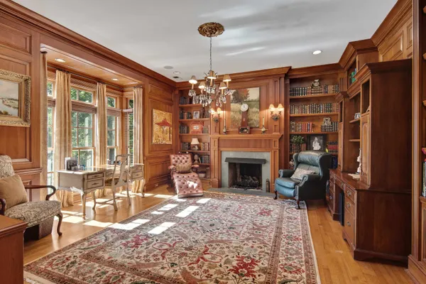 a living room with furniture a fireplace and a chandelier