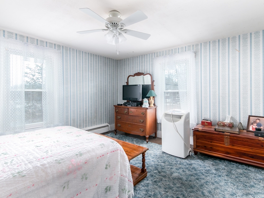 68 Durham Road Dover, NH 03820 - Photo 12 of 23 a bedroom with a bed and a chandelier