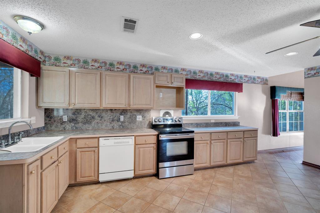 488 Loma Linda Road Palmer, TX 75152 - Photo 25 of 39 a kitchen with stainless steel appliances granite countertop a stove and cabinets