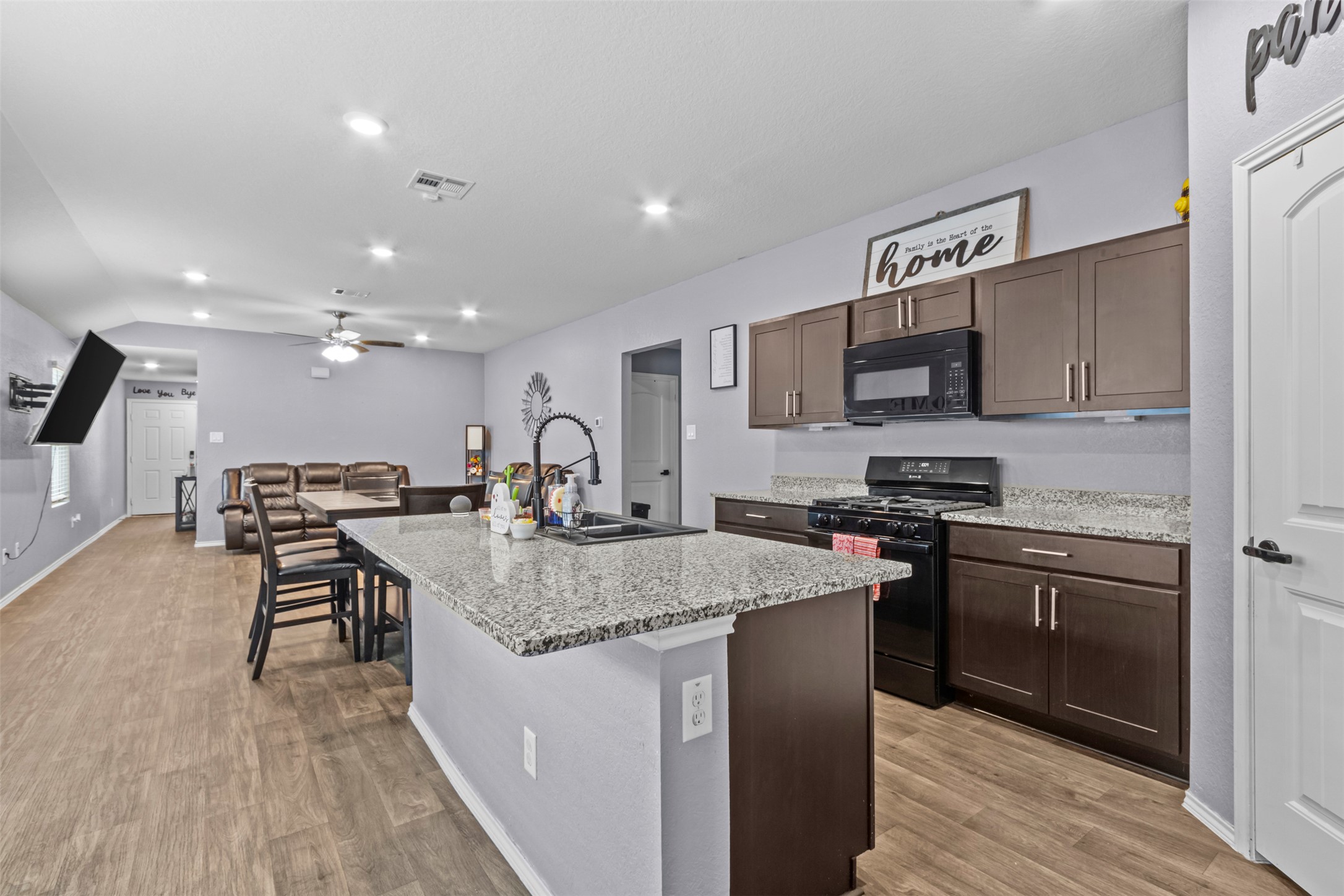 339 Euclid Lane Kyle, TX 78640 - Photo 8 of 17 a kitchen with kitchen island granite countertop a stove top oven a sink dishwasher a dining table and chairs with wooden floor