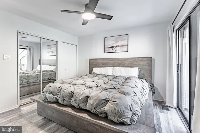 a large bed sitting in a bedroom next to a window and a chandelier