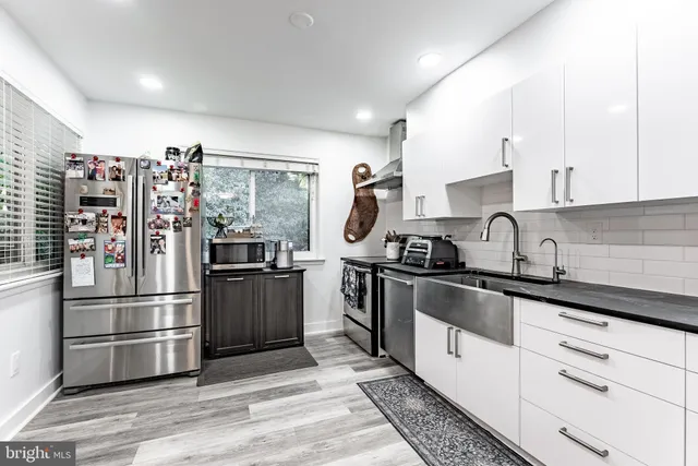 a kitchen with stainless steel appliances granite countertop a refrigerator sink and stove