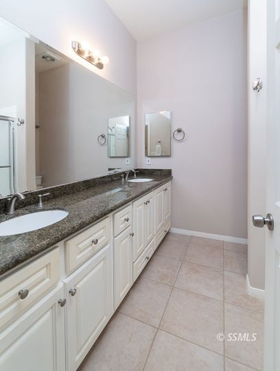 411 North Nolan Street Ridgecrest, CA 93555 - Photo 26 of 43 a bathroom with a granite countertop sink and a mirror