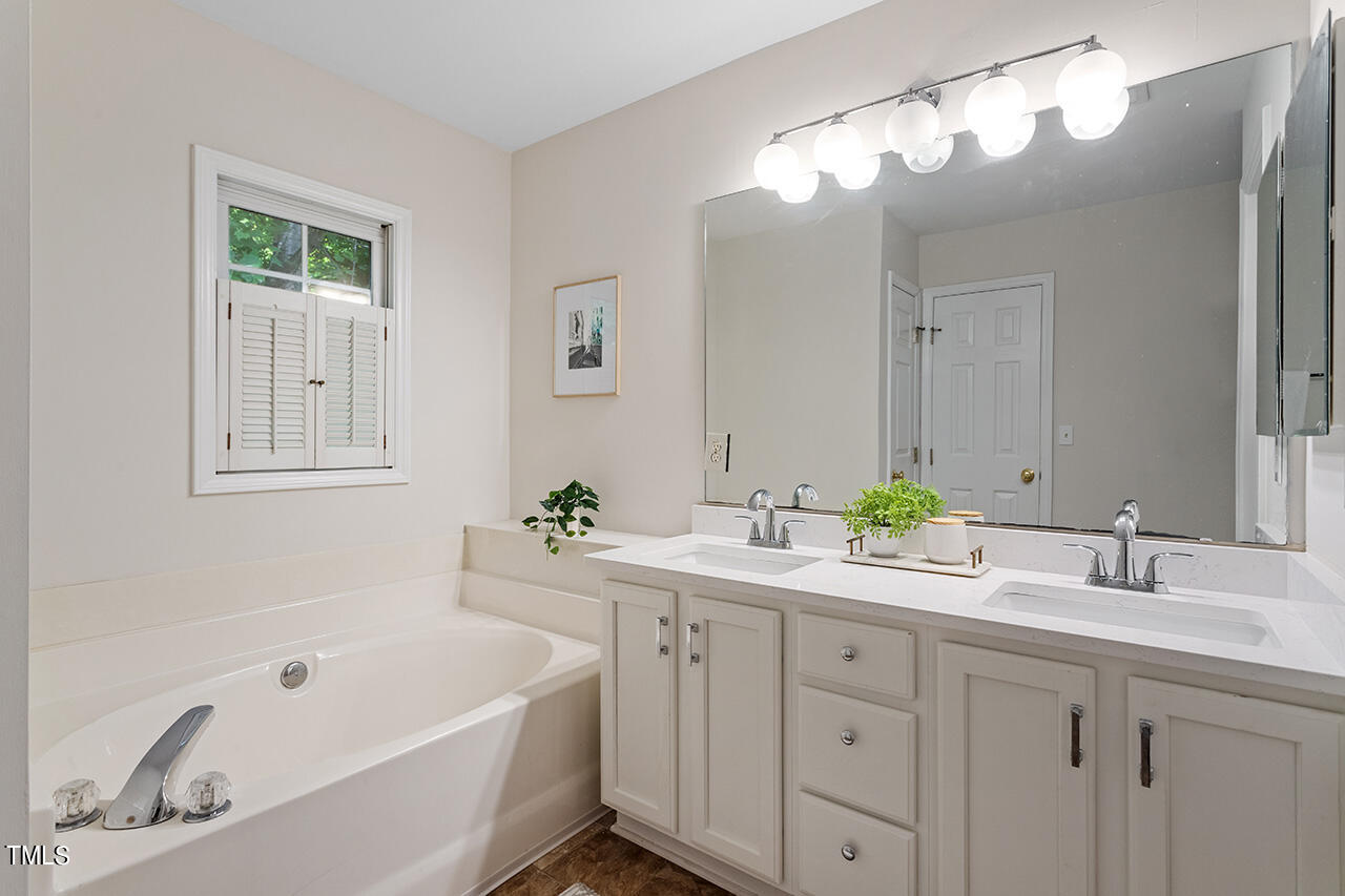 12601 Waterlow Park Lane Raleigh, NC 27614 - Photo 22 of 38 a bathroom with a tub a sink and a mirror