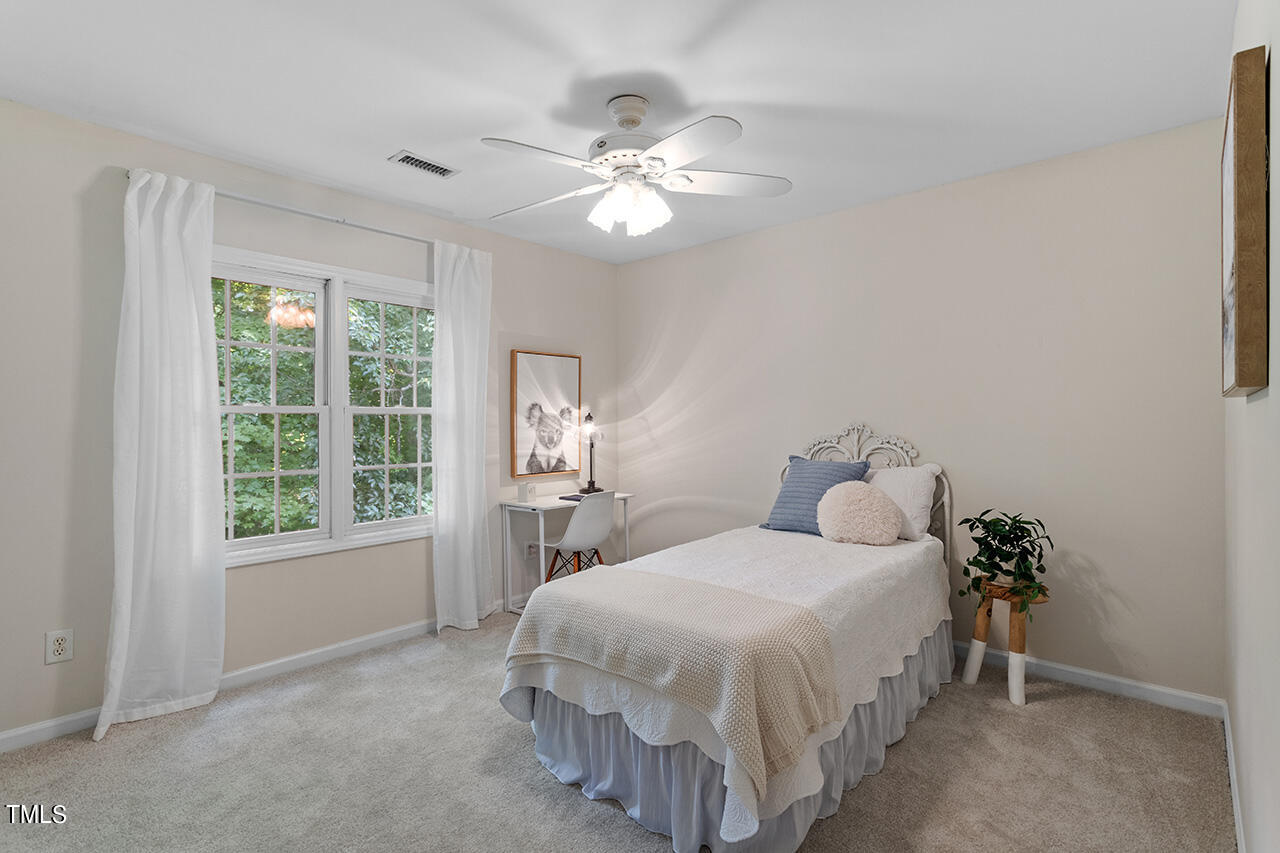 12601 Waterlow Park Lane Raleigh, NC 27614 - Photo 28 of 38 a bedroom with a bed and a chandelier