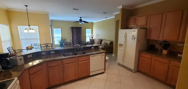 a kitchen with stainless steel appliances granite countertop a refrigerator a sink and dishwasher
