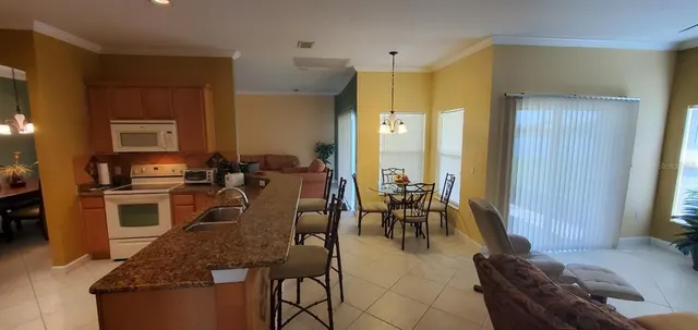 a large kitchen with granite countertop lots of counter space and furniture