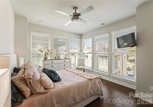 a bedroom with a bed and a large window with the outer view